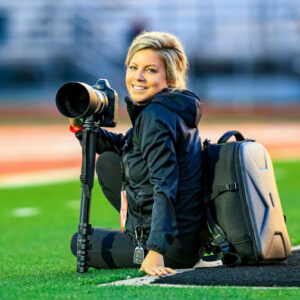 Ashley Dixon Sports Photographer Ashley Dixon - Sports photographer on a football field with her camera.